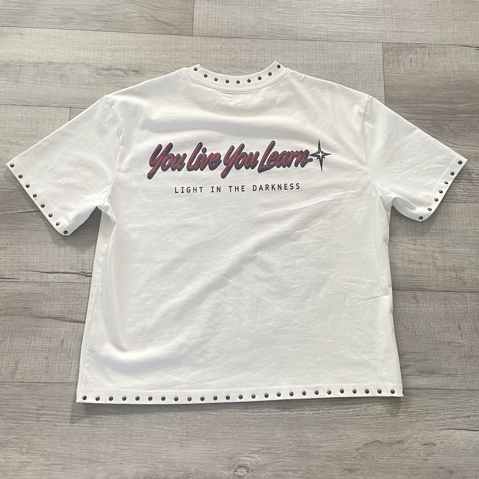 Back of the shirt with You Live You Learn graphic